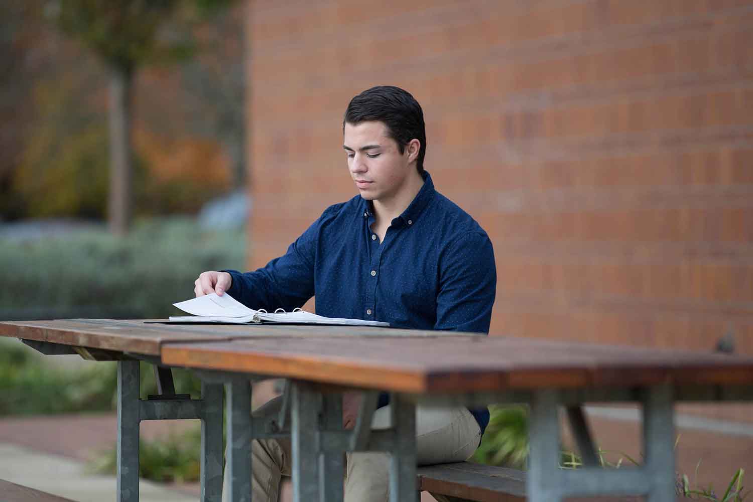 Student reading outside on camera